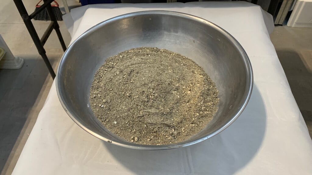 Hypertufa ingredients being mixed by hand in a metal bowl