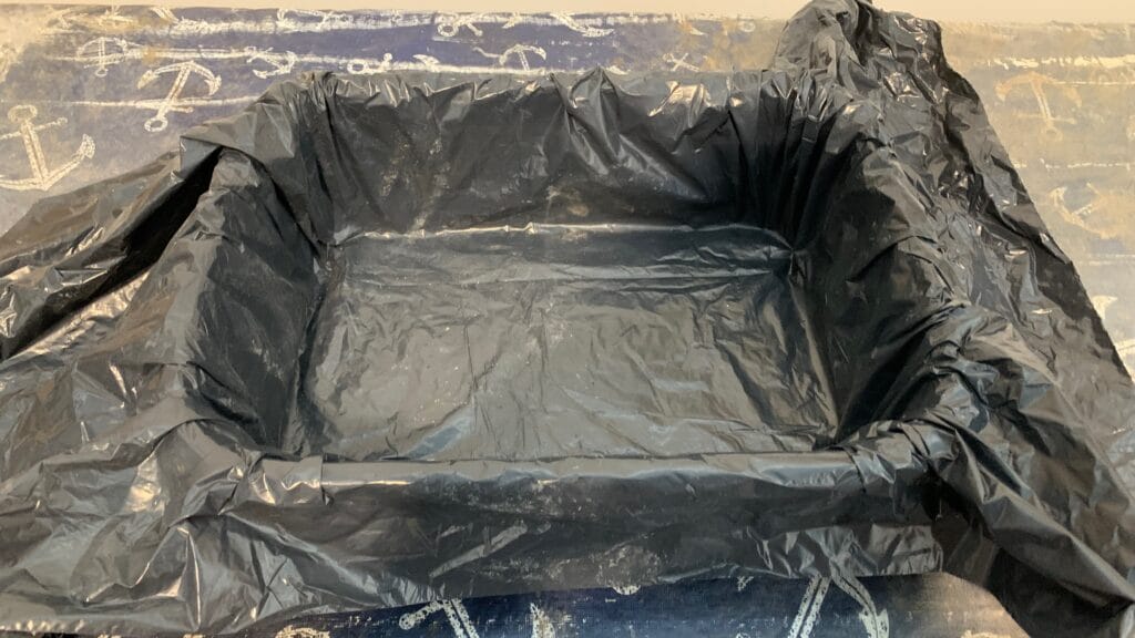 A plastic liner is placed inside the mold to prepare for the hypertufa mixture